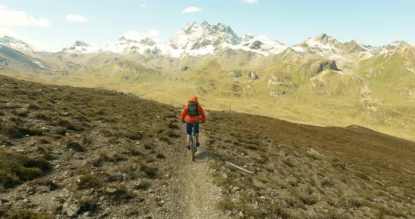 Single trail mountain bike fun in the austrian alps with beautiful snow covert mountains in the back alt