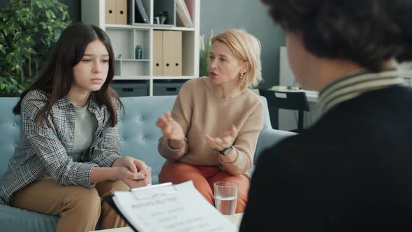 Mature Woman Yelling at Teenage Girl in Psychologist's Office While Therapist Listening and Writing alt
