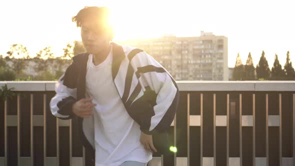 Portrait of a Young Modern Street Hip-hop Dancer. Asian Man Walks and Dances in the Street alt