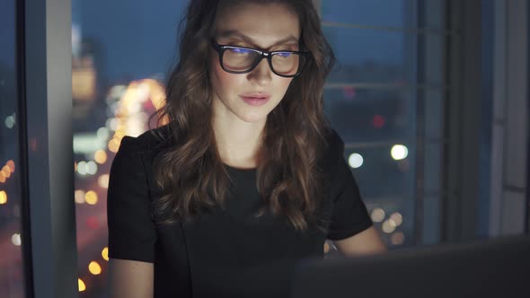 Closeup Portrait of Business Woman on Night City Background. the Girl Works Late in the Office alt