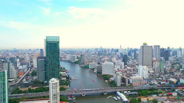 Aerial view flight over moving sky train on a bridge over the Chao Phraya River alt