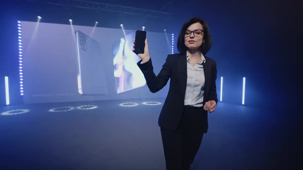 The Presenter Holding a New Smartphone alt