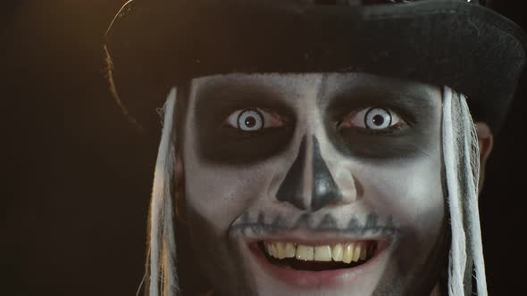 Portrait of Scary Guy in Thematic Costume of Halloween Skeleton Exhaling Cigarette Smoke From Mouth alt