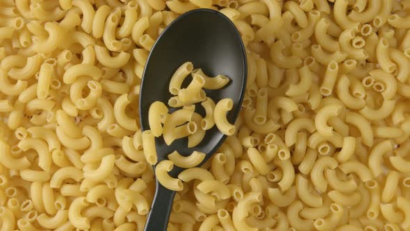 Spoon with a figural pasta falls on a figural pasta