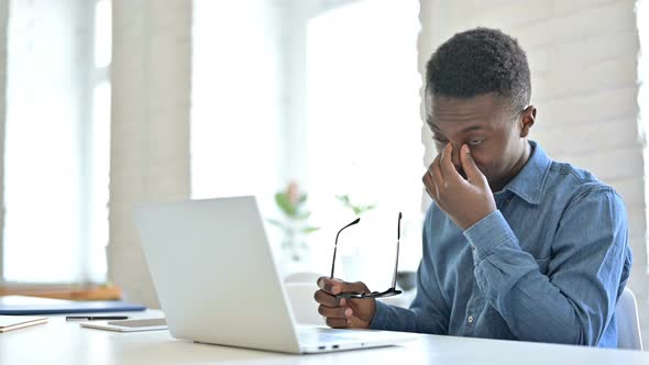 Young African Man with Laptop having Headache  alt