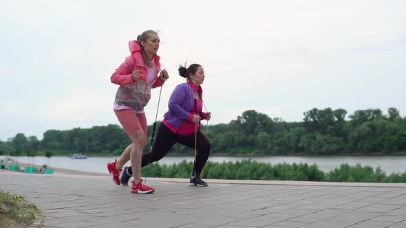 Fat Young Woman Doing Squats Exercises Using Fitness Tape for Weight Loss with Personal Trainer alt
