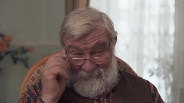 Portrait of Adult Darling Grandfather with a Big Beard and a Kind Look Who Corrective Glasses on the alt