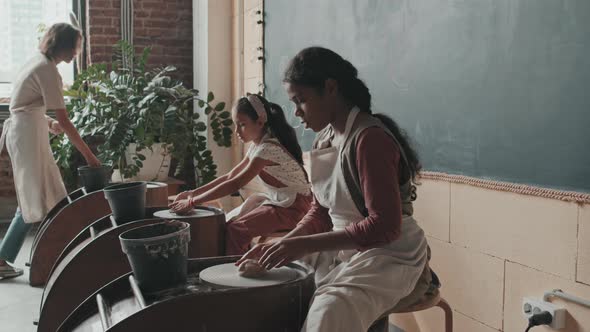 Children Sitting at Pottery Wheel alt