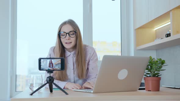 A woman leads an online broadcast live of a training blog on investment, finance, business. alt