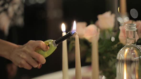 The Girl Lights Candles on Candlesticks. Romantic Candlelight Dinner