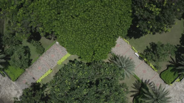 long shot top down symmetrical aerial view of modern urban park featuring lakes, lush gardens, bridg alt