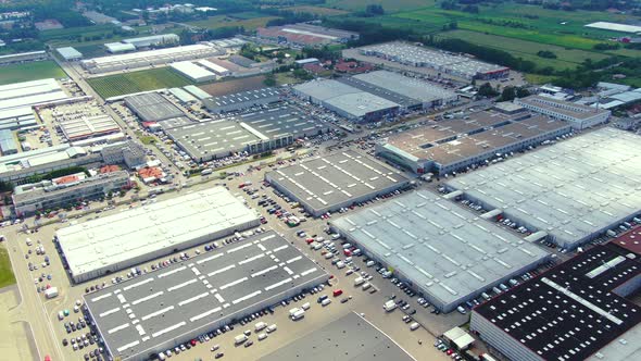 Aerial footage of a large shopping centre and car parks located in the city alt