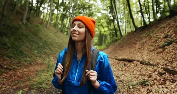 Woman with Backpack Walking in Forest