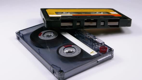 Two Vintage Audio Cassette Rotates on White Background alt