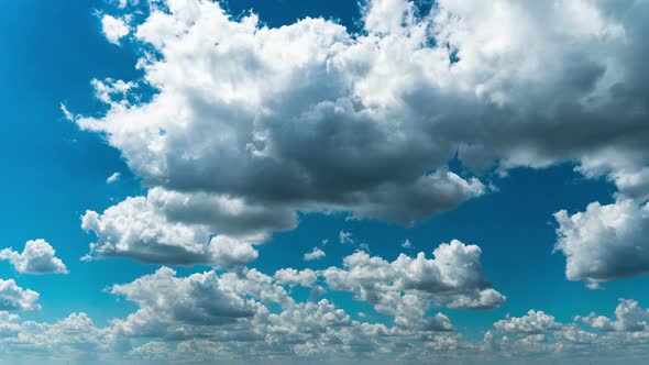 White Fluffy Clouds Slowly Float Through the Blue Daytime Sky Timelapse alt