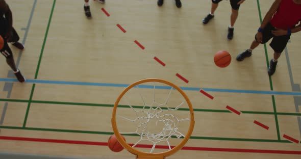 Overhead view of african american male basketball player scoring goal against diverse players alt