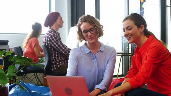 Business executives discussing over laptop alt