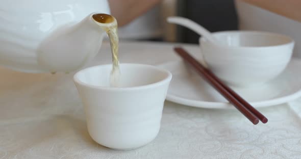 Pouring hot tea in chinese restaurant  alt