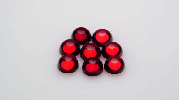 Natural Red Garnet Gemstone on the White Background on the Turning Table alt