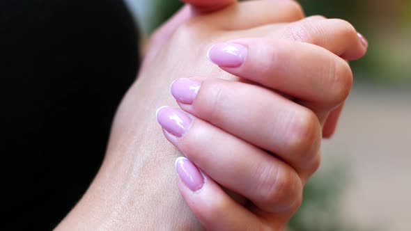 A woman with a beautiful manicure stroke her hands, close-up of female hands.