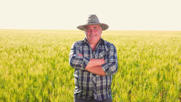 Positive Farm Worker with Arms Crossed Amidst Crops alt