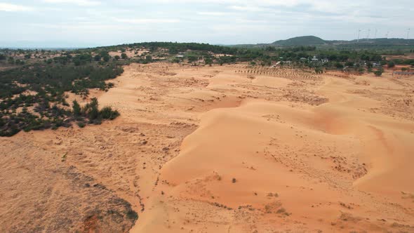 aerial top down of dry arid desert landscape surrounded by trees in Mui Ne Vietnam alt