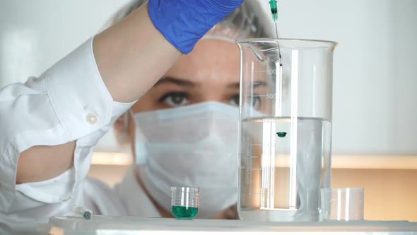 Scientist Woman Pours Chemical Research in Laboratory Pours Reagent Into Flask
