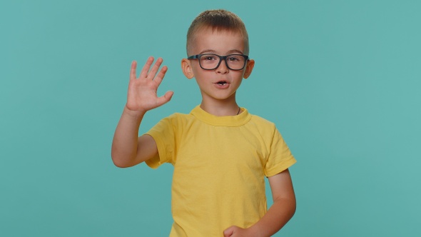 Happy Toddler Children Boy Smiling Friendly at Camera and Waving Hands Gesturing Hello or Goodbye alt