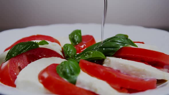 Pouring Olive Oil Over Italian Caprese Salad  02