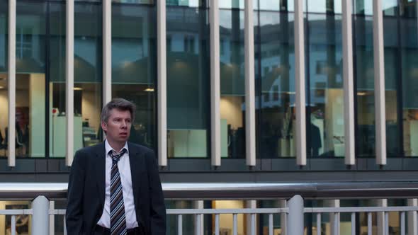 Day to Night Timelapse of A Businessman Standing Still Outside the Office