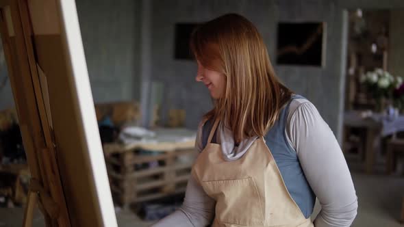 Portrait of Caucasian Woman Painting in Arts Studio Using Smear and Oil Paints alt