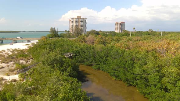 Fly over mangroves revealing hotels and main highway in Lovers key, Florida alt