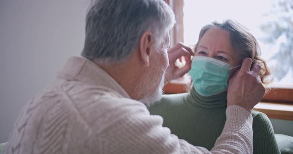 an Elderly Man Removes the Mask From His Elderly Wife and Kisses Her on the Lips alt