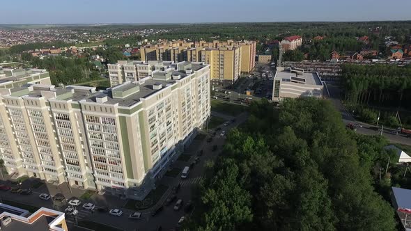 An Aerial View of Multi Storey Buildings Next To the Green Forest Against Blue Sky alt