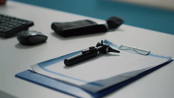 Close Up of Otoscope and Medical Documents on Desk alt