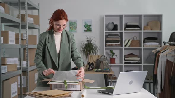 Retail Shop Online Young Business Woman Clothes Packing a Parcel Using a Laptop to Send to Customers alt