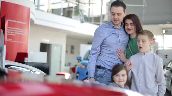 Happy family with a dealer, buying a new electric car alt