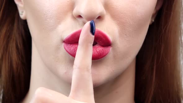 Woman Holding Her Finger To Her Lips in a Gesture for Silence. Closeup alt