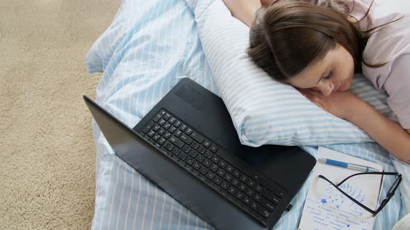 Tired Student Girl with Laptop Sleeping at Home