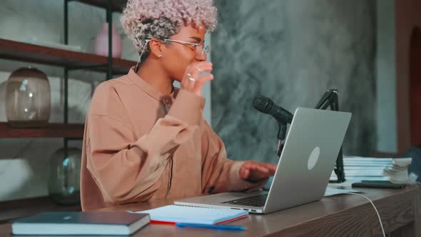 Young African American Woman with Smile Waving Hands Sits at Table with Laptop alt