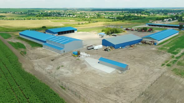 Warehouses with Blue Roofs Among the Wheat Fields alt