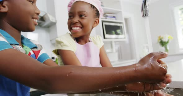 Children washing hands in kitchen alt