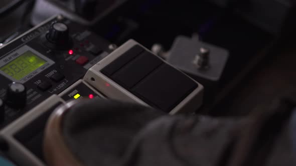 Man using a guitar effects pedal - turns on the delay and taps in the tempo alt