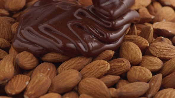 Melted chocolate pouring over almonds