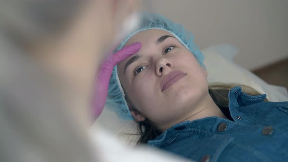 Woman Talks with Cosmetologist About Brow Tattooing alt