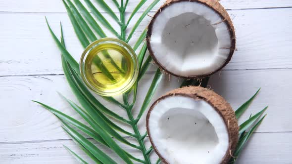 Slice of Fresh Coconut and Bottle of Oil on a Table alt