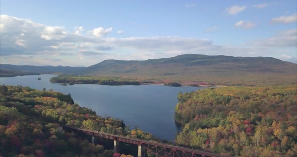 Lake Onawa and the Onawa trestle train tracks surrounded by colorful autumn trees AERIAL. alt