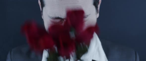 A man smacking his face with roses