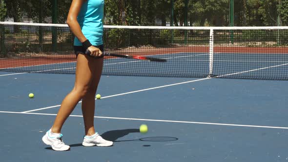 Legs of Woman Beating Tennis Racket on Ball Near Net on Court