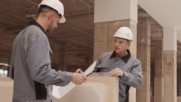 Colleagues Using Spirit Level in Construction alt